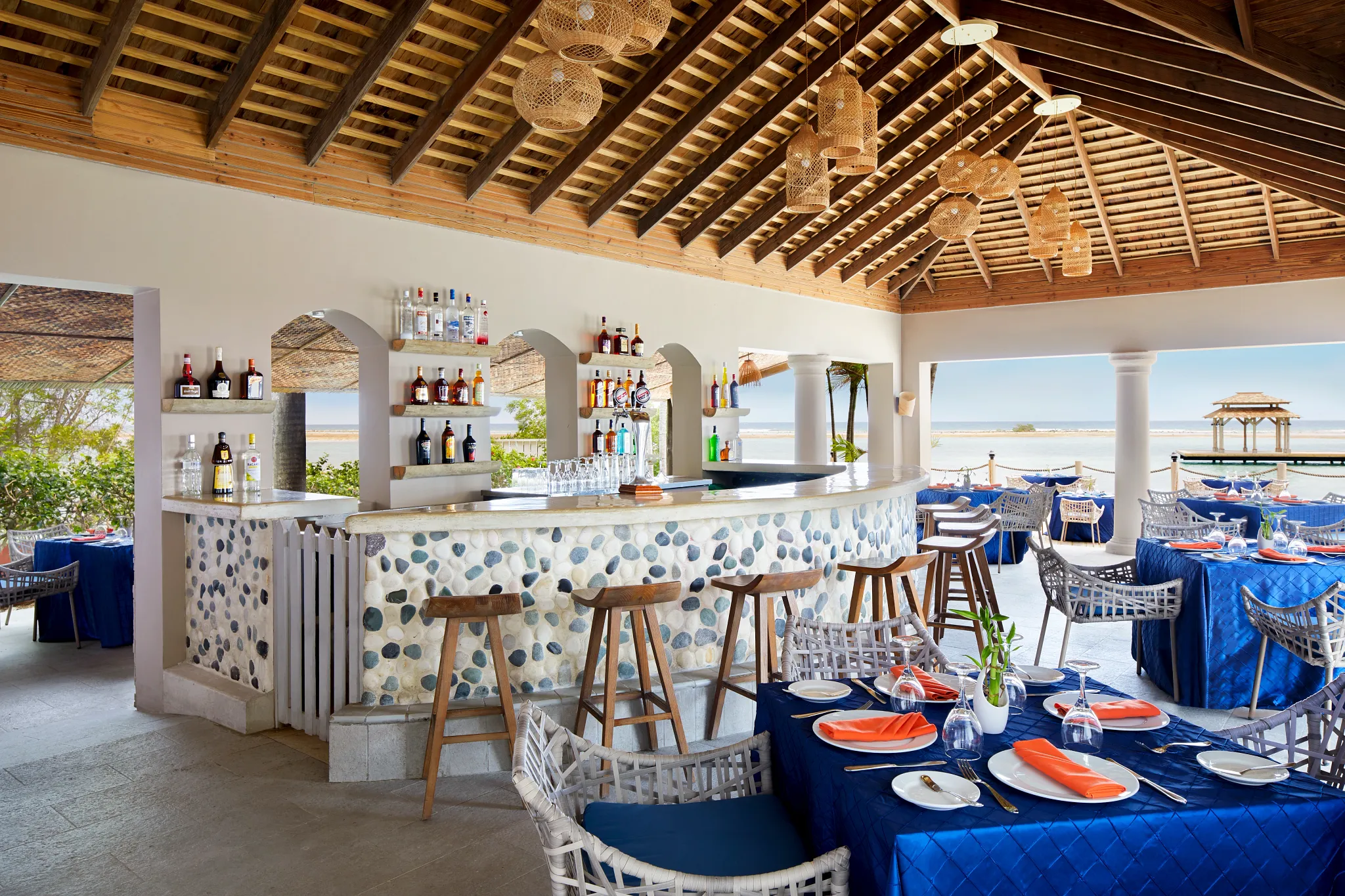 Canoa Restaurant at Zoëtry Montego Bay Jamaica featuring an open-air oceanfront bar, Caribbean Sea views, and elegant island-inspired dining setting.