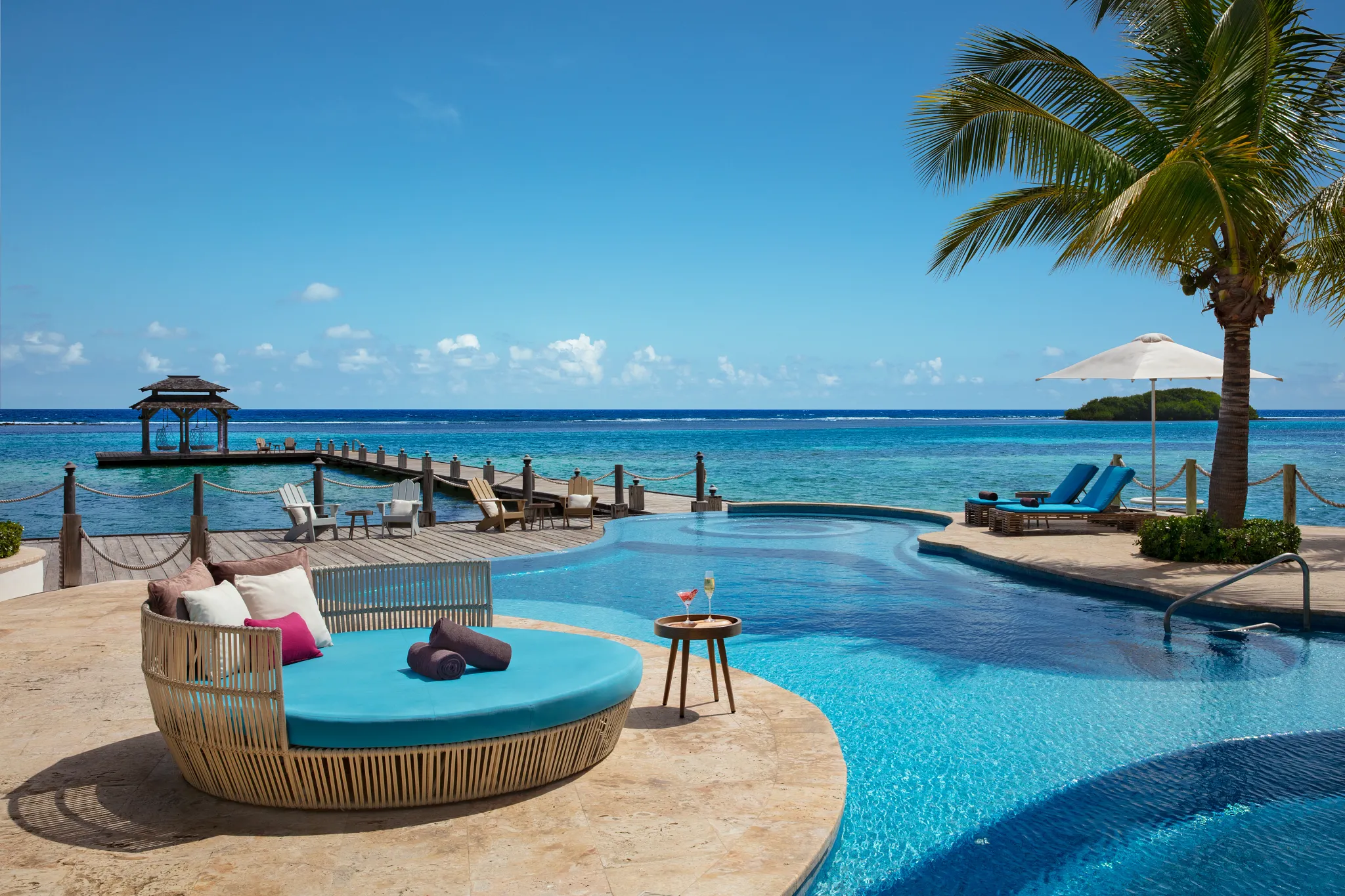 Oceanfront pool with lounge chairs and private pier at Zoëtry Montego Bay Jamaica.