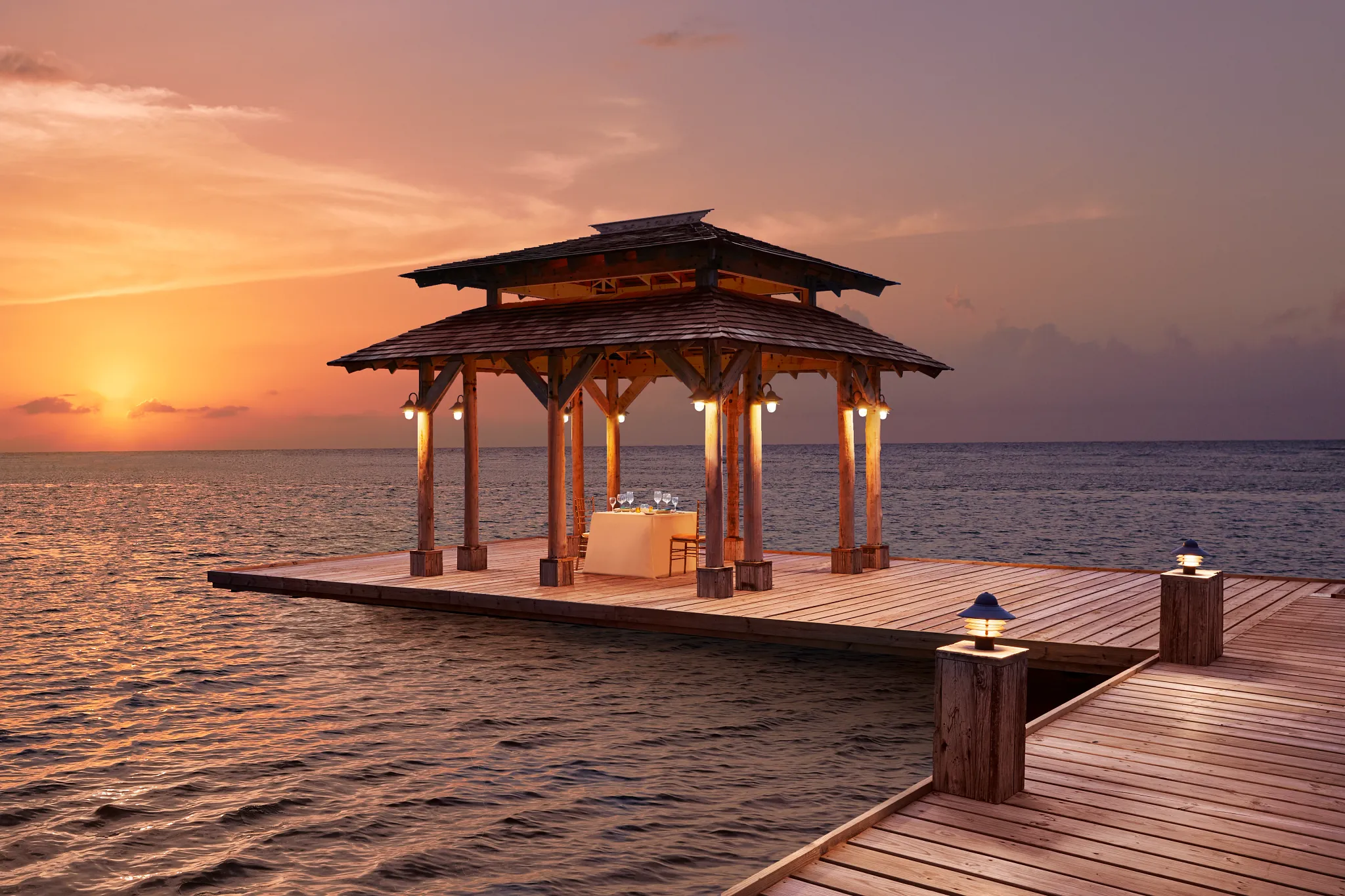 Private overwater gazebo set for dinner at sunset at Zoëtry Montego Bay Jamaica.